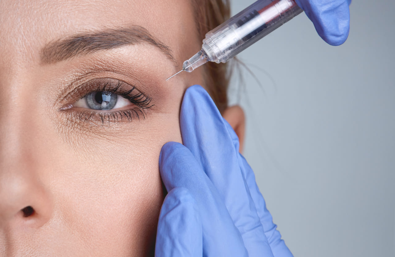 woman getting a botox injection to raise her eyelids