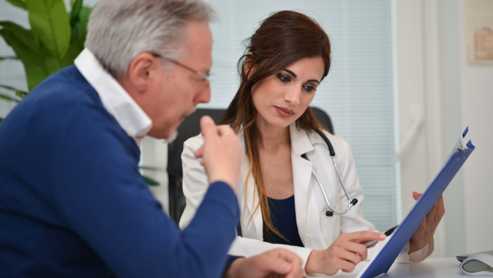 Female doctor explaining Cingal injections to male patient.