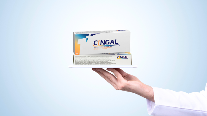 Doctor holding up Cingal boxes.