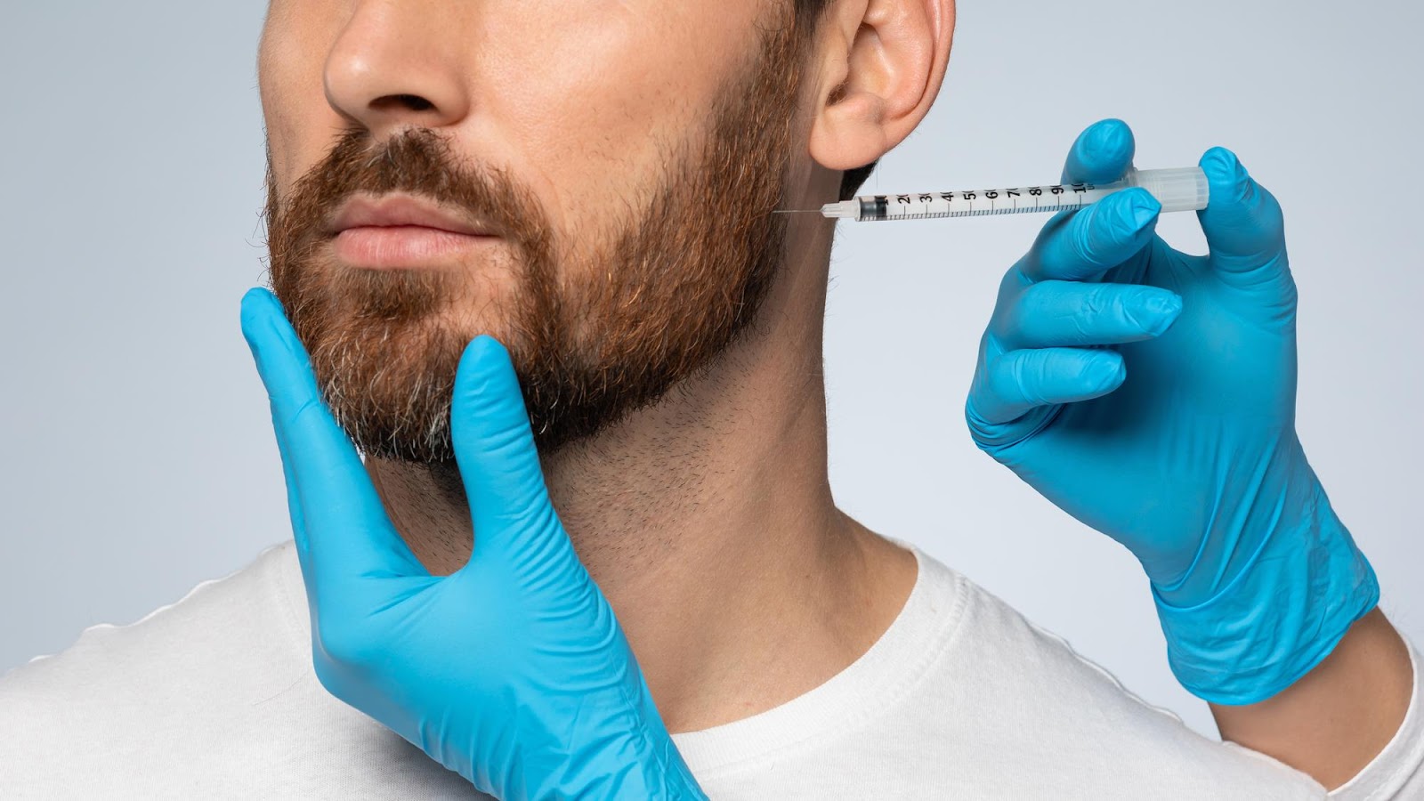 Male patient receiving Radiesse to contour his jawline.