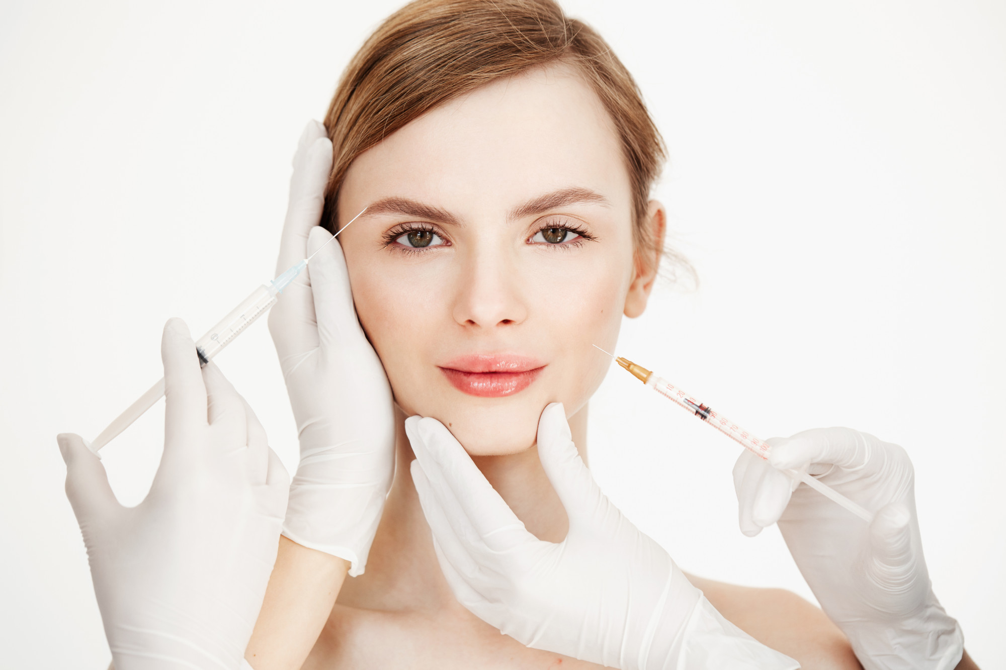 Beautiful woman with glowing skin receiving facial injection to lift the skin.
