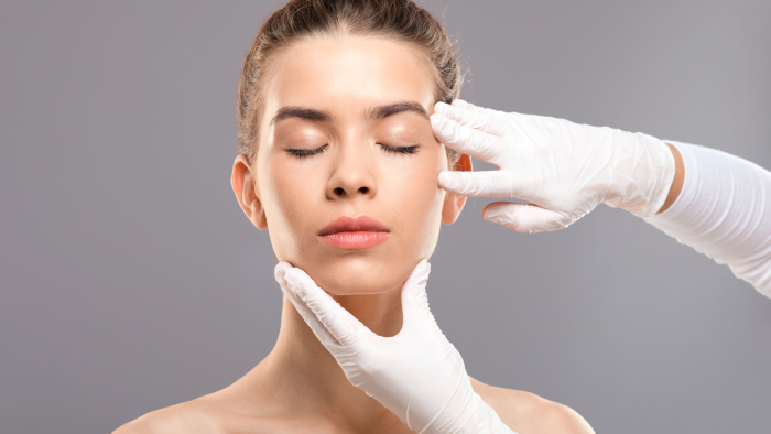 Healthcare professional examining a patient's face before Teosyal treatment.