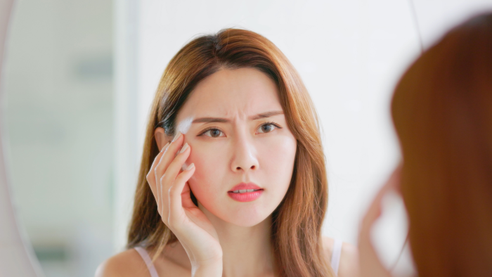 Woman bothered by signs of aging on the face.