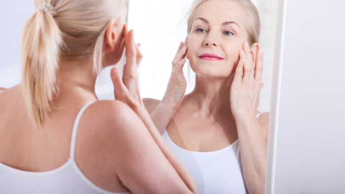 Woman checking her complexion in the mirror.