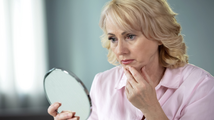 Woman bothered by undefined facial contours.