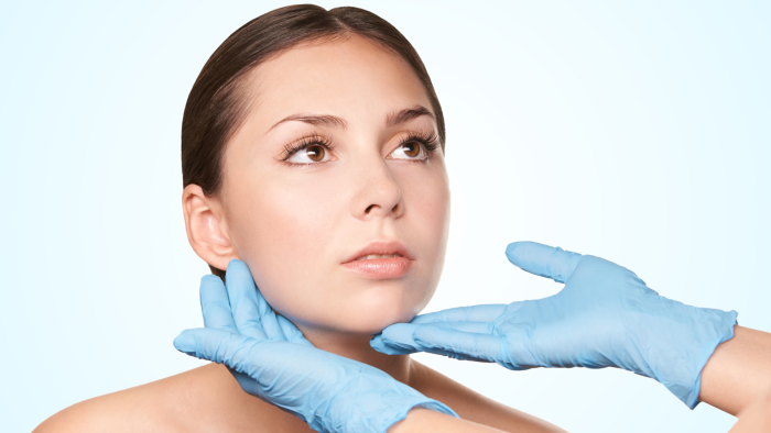 Healthcare professional examining a female patient's skin.