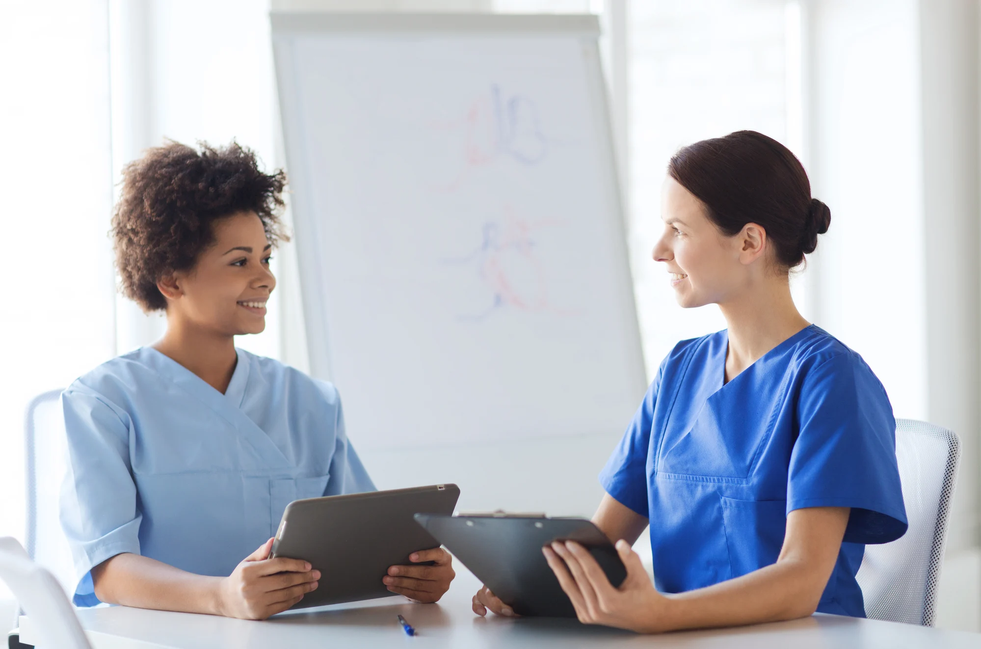 two nurses discussing patient education strategies