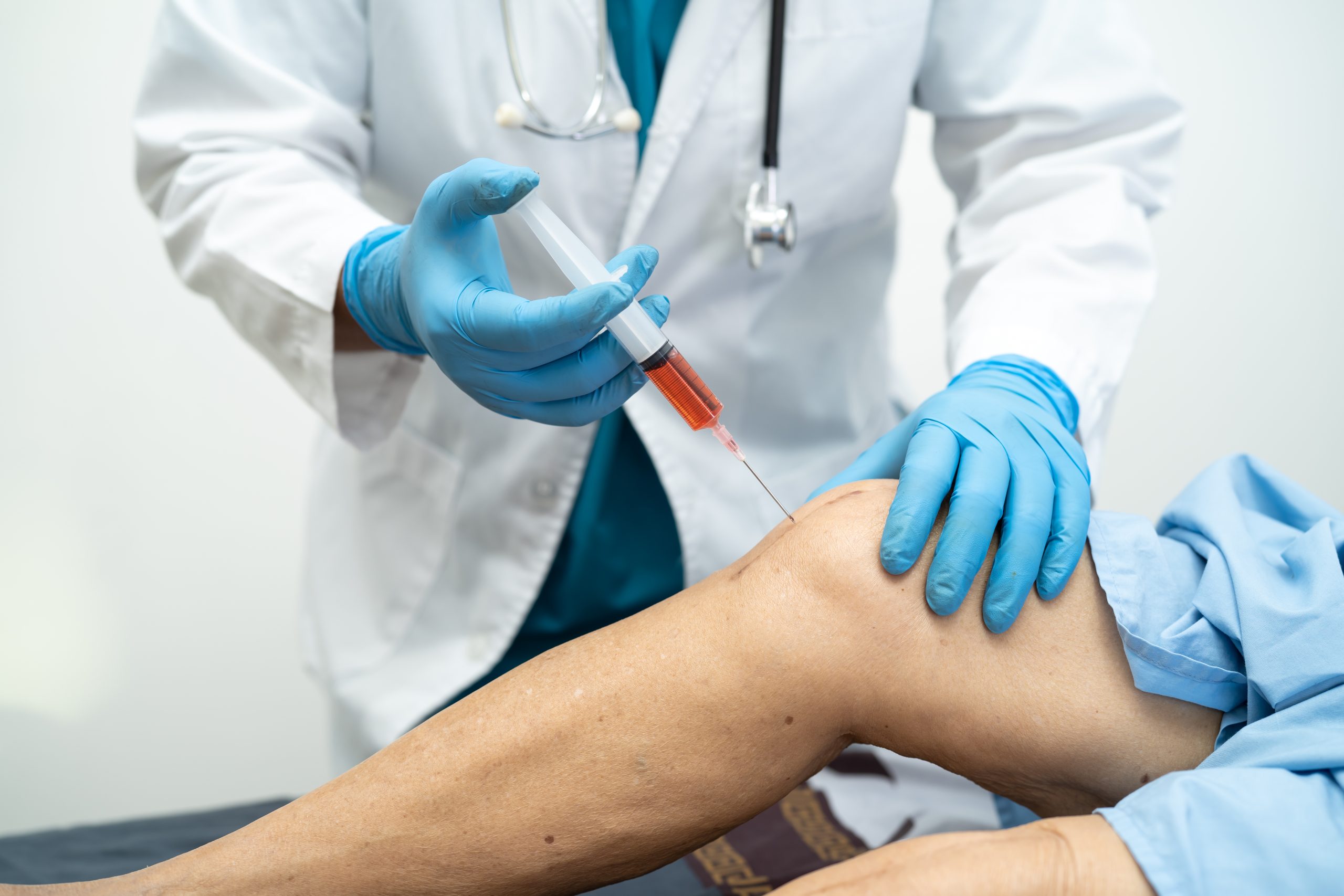 Asian doctor inject Hyaluronic acid platelet rich plasma into th