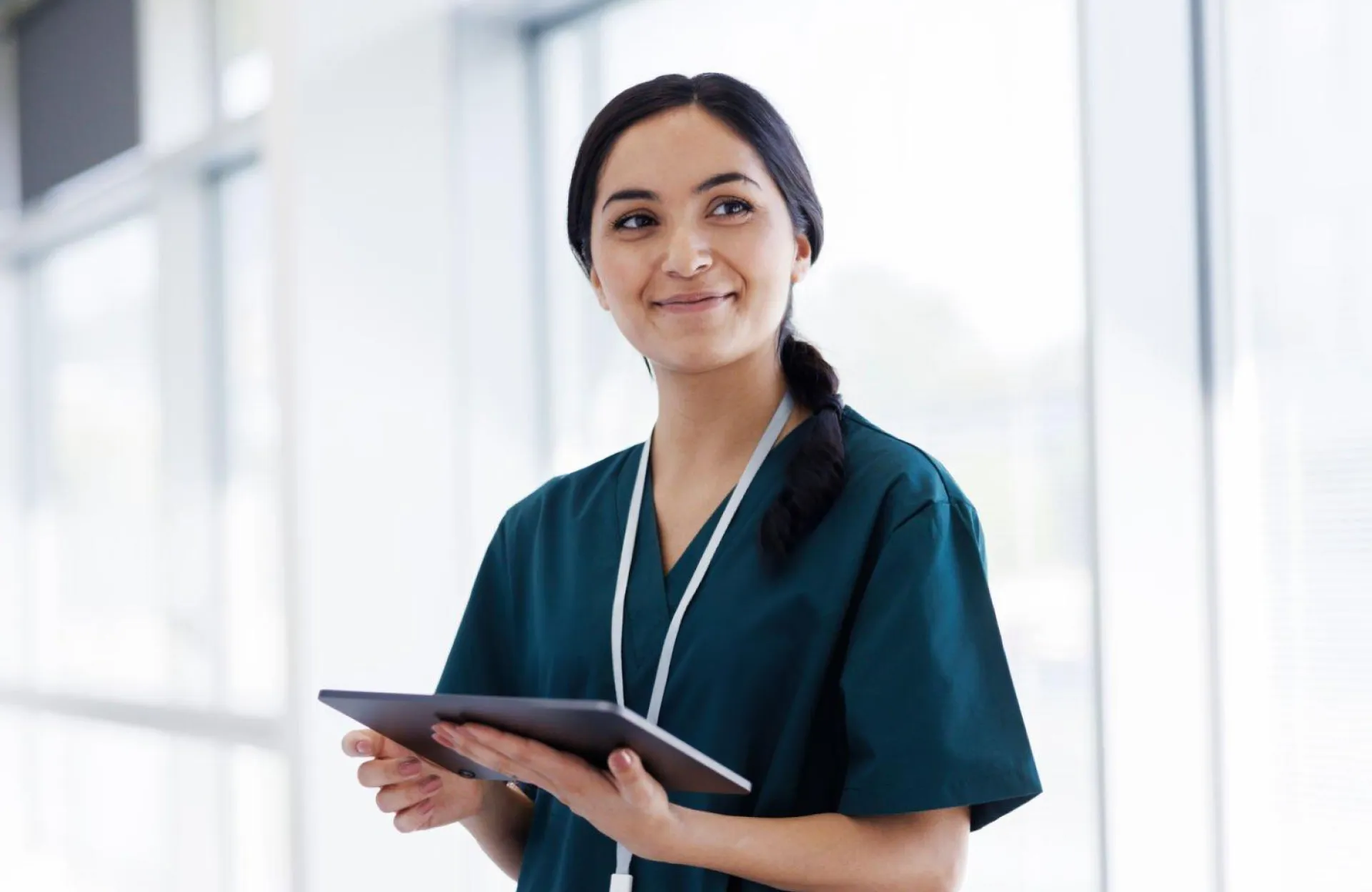 Nurse practitioner in dark blue scrubs, smiling