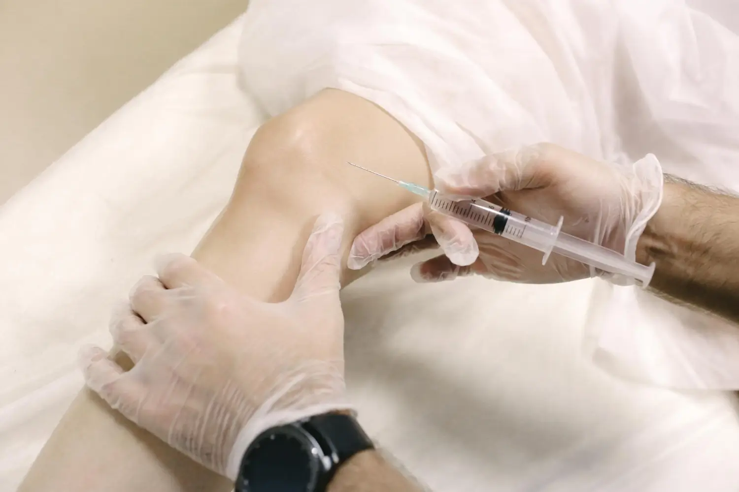 doctor gently injecting treatment into the knee