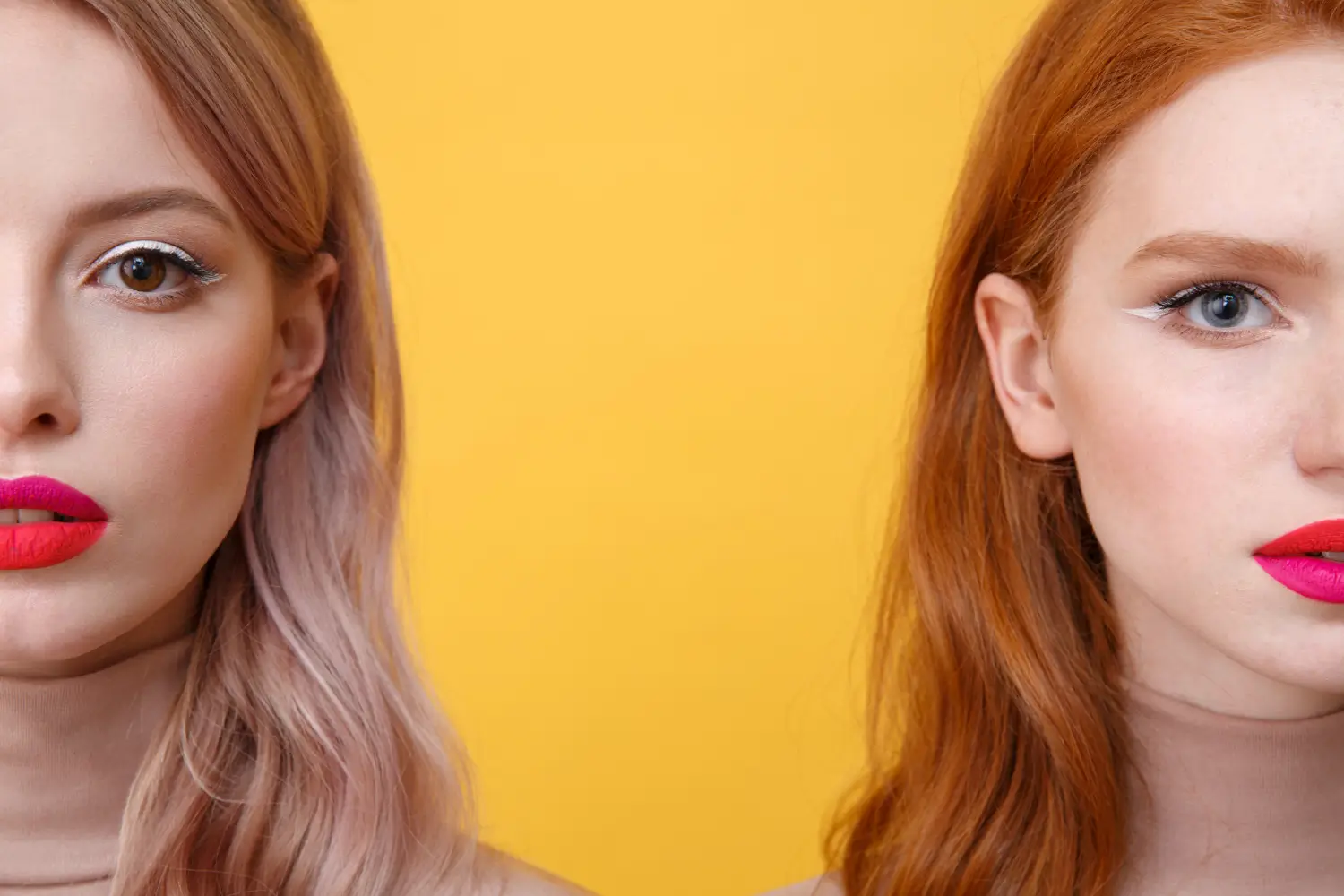 Two women with vibrant makeup against a yellow background. The left woman has pastel pink hair and bright pink lipstick, while the right woman has reddish hair and deep pink lipstick. Both have winged eyeliner, with only half of each face visible.