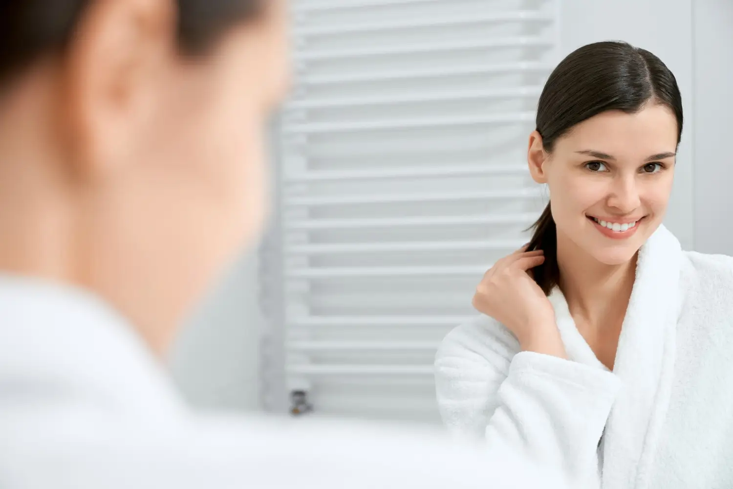 teh mirror shows woman's fresh-looking skin