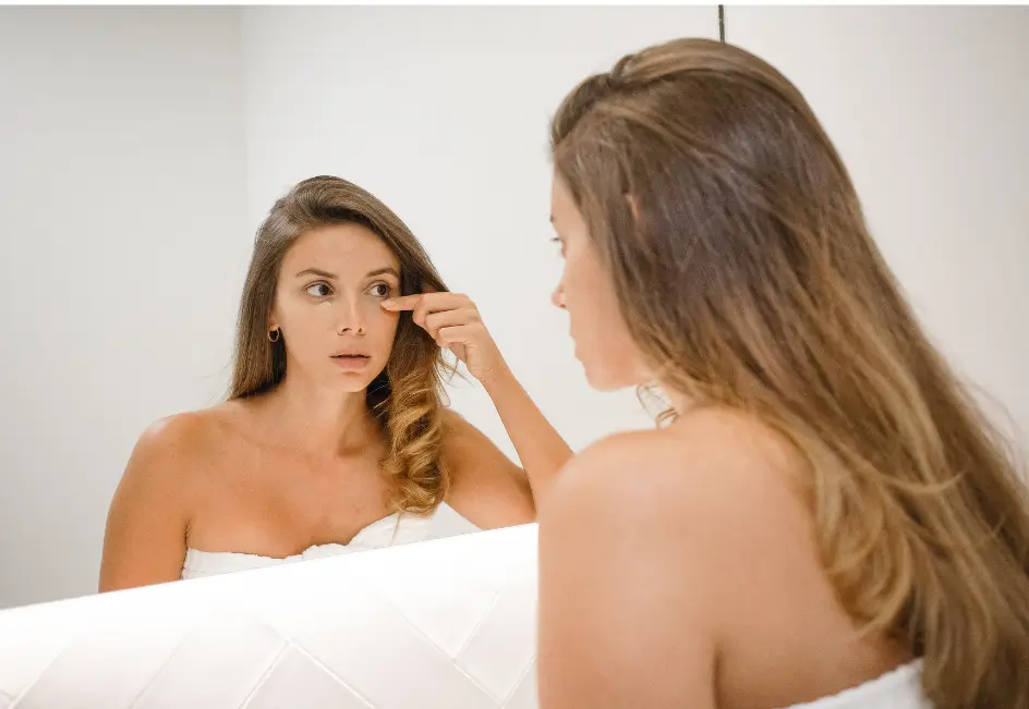 woman looking in the mirror for results