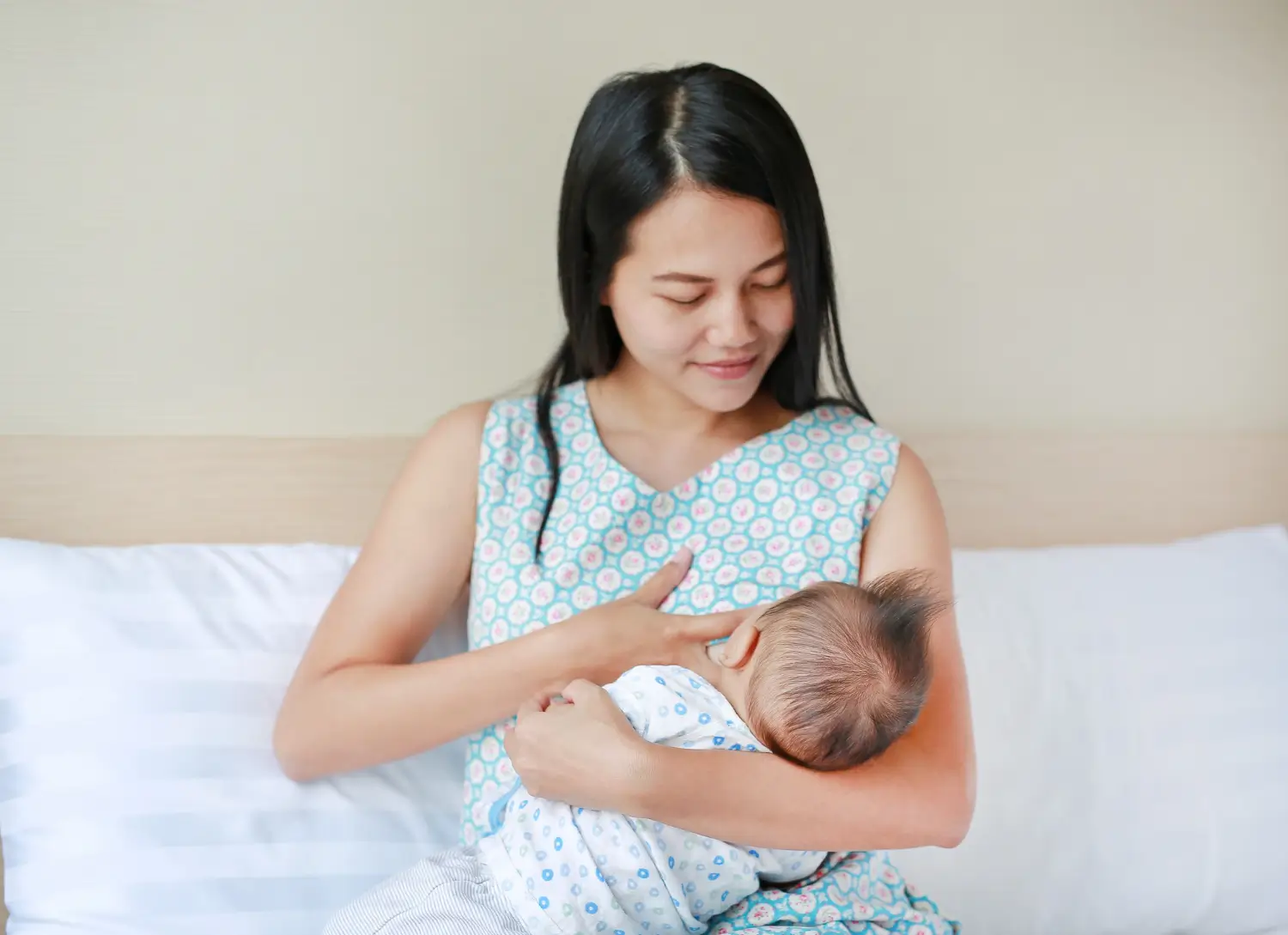 mother breastfeeds baby in her arms