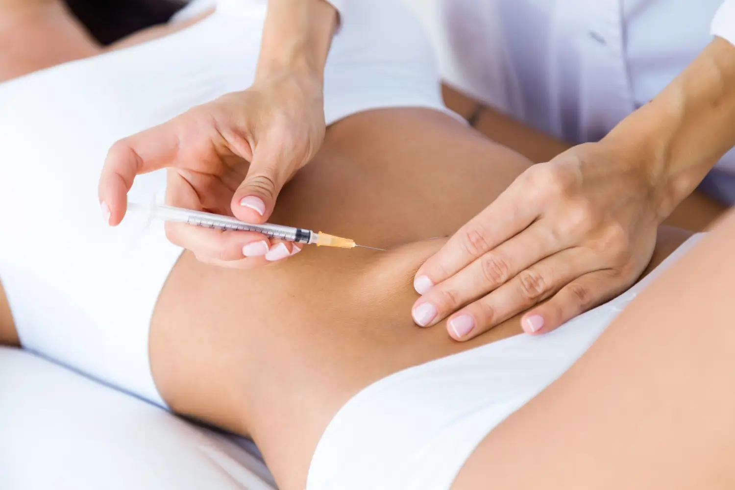Cosmetic doctor injects fat dissolving solution to the patient's abdomen,