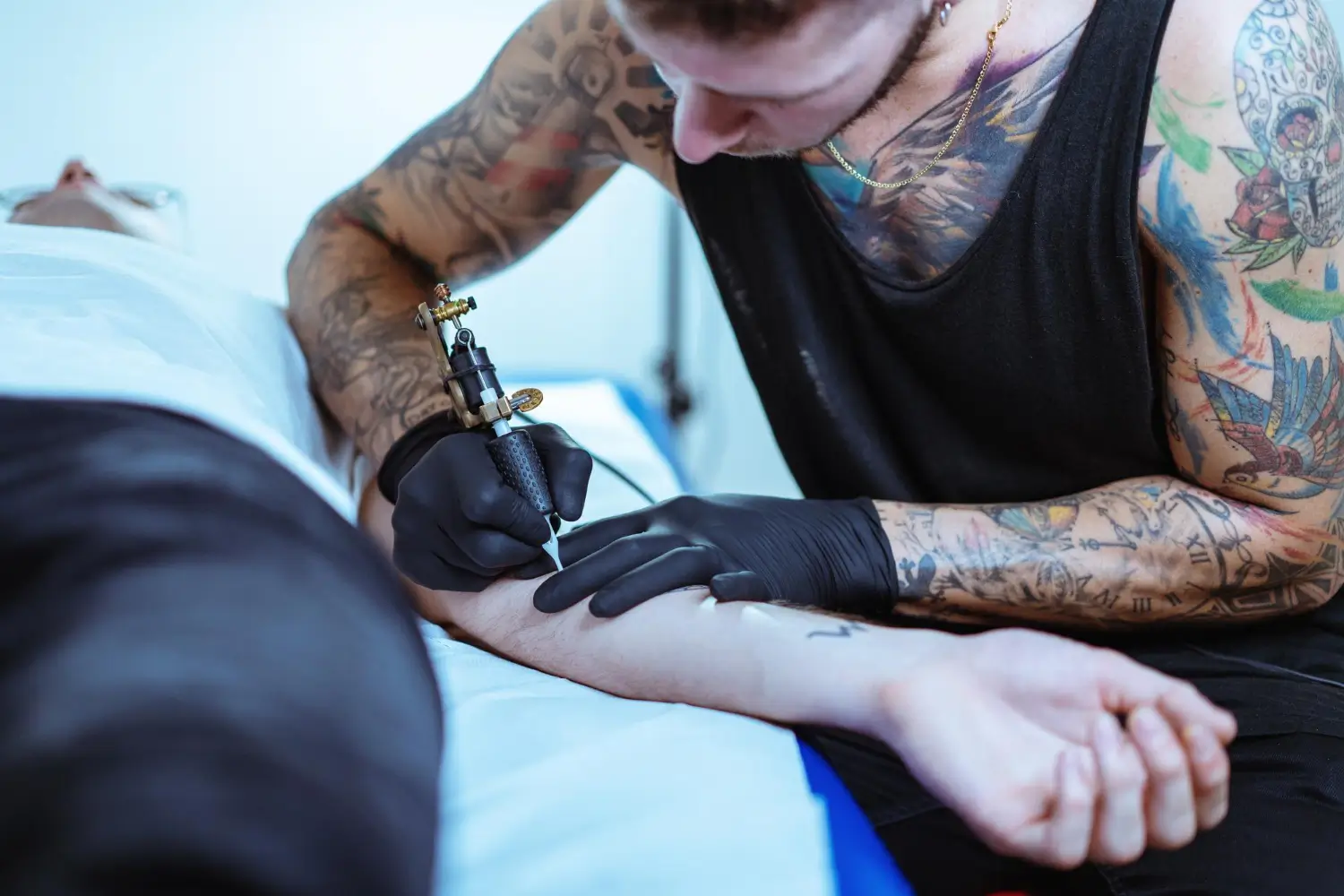 doing a tattoo on the client's arm
