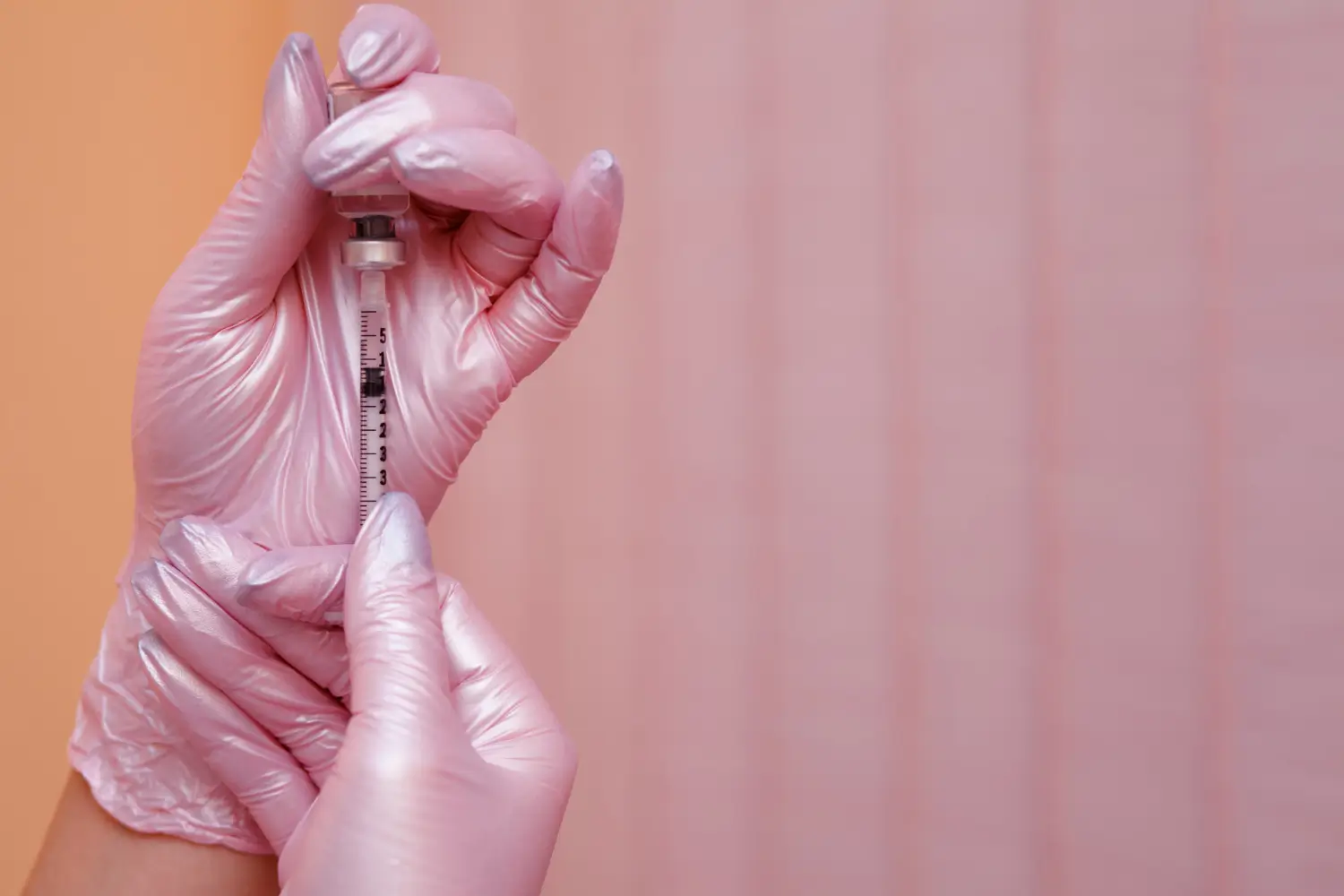 doctor wears pink gloves to prepare the injection