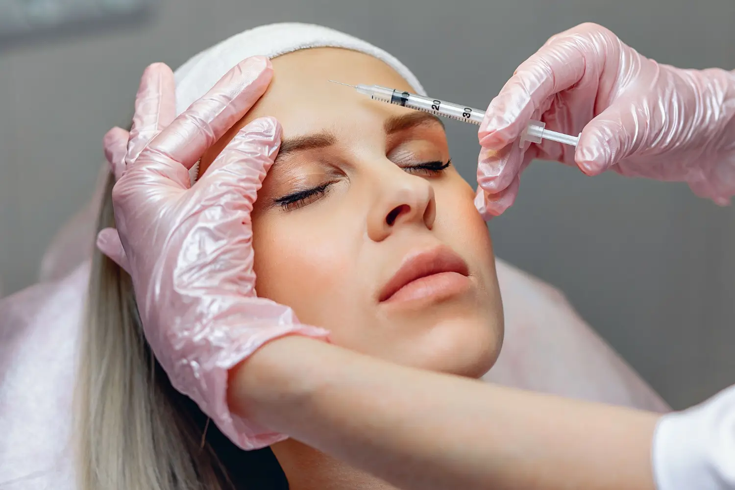 Patient getting an injection for removing wrinkles, such as Dysport, on her forehead.